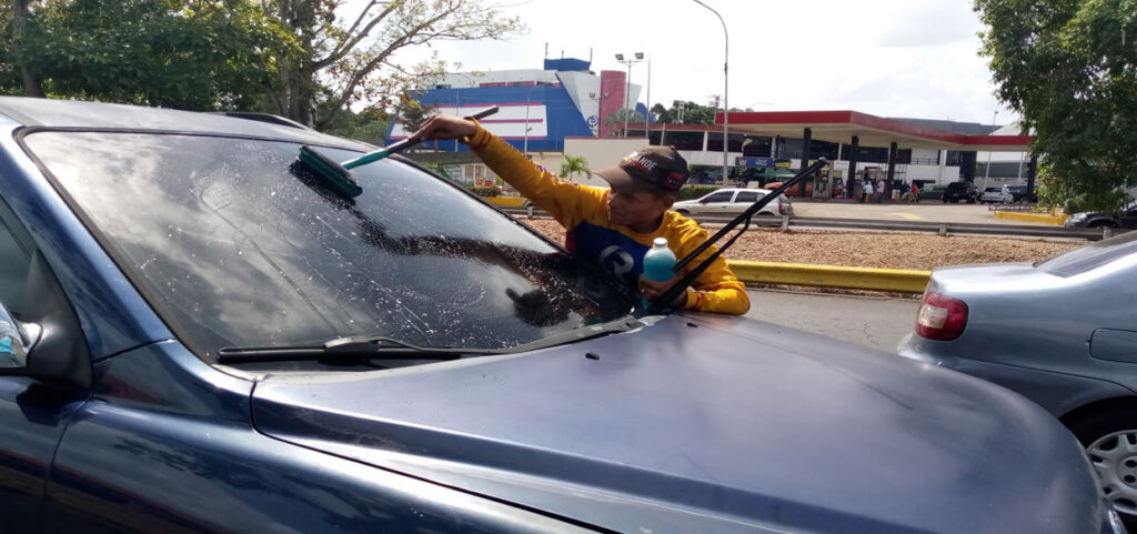 Jóvenes se ganan la vida limpiando parabrisas